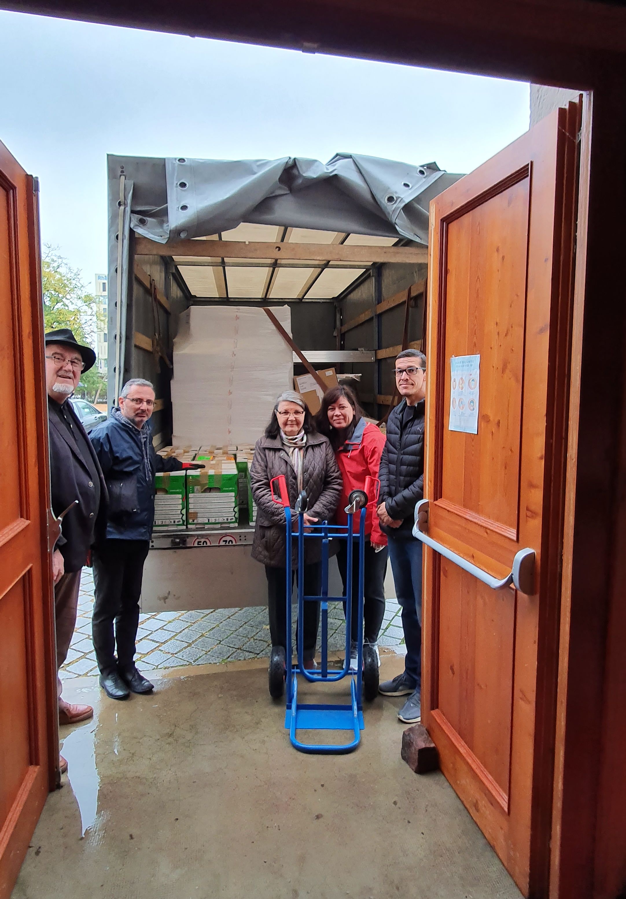 Paroissiens à l'arriere du camion avec les cartons chargés